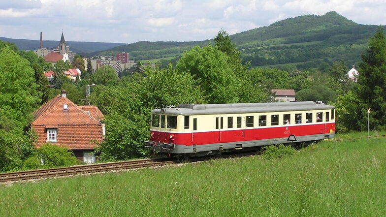 Auf der Strecke fahren nur historische Schienenbusse,  im Hintergrund liegt die Kleinstadt Jílové u Decína (Eulau) mit der Dreifaltigkeitskirche.