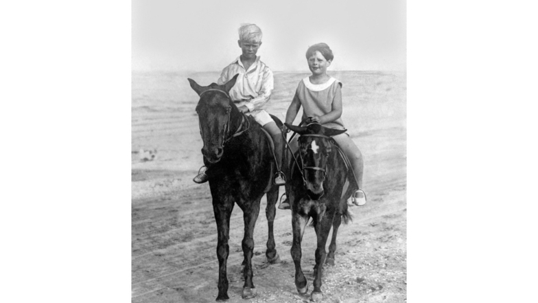 1928: Prinz Philip (l) reitet auf einem Pferd neben dem rumänischen König Michael am Strand von Constanza.