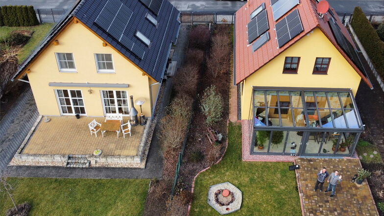 Der Fotograf ließ die Drohne steigen: Die zwei Solar-Fans Steffen Metzler (r.) und Bernd Anders stehen in der Schillerstraße in Coswig vor ihren Häusern mit neuen Photovoltaikanlagen. 50 bis 70 Prozent ihres gesamten Stroms produzieren sie selbst.