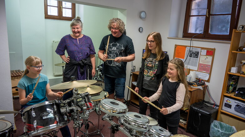 Musikschullehrer Tim Dirks (Mitte) freut sich über das Interesse von Luise (links). Sie hat mit zehn Jahren das optimale Alter, um Schlagzeug spielen zu lernen.