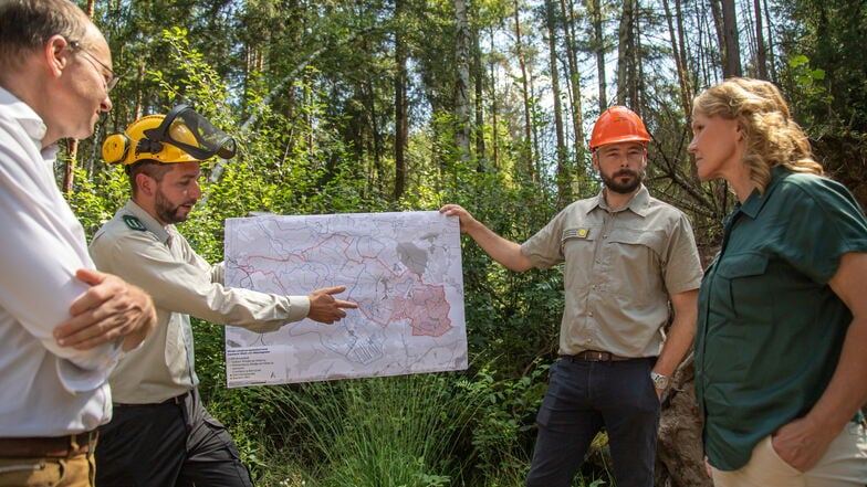 Bundesumweltministerin Steffi Lemke und Sachsens Umweltminister Wolfram Günther (beide Grüne) besuchen den Daubaner Wald, um ein Wildnisgebiet zu begründen. Mitarbeiter von Sachsenforst zeigen die Größe der Waldfläche auf einer Karte.