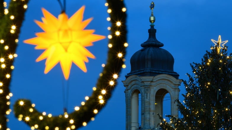 Ein Herrnhuter Stern und ein beleuchteter Weihnachtsbaum sind auf dem Altmarkt vor der Frauenkirche zu sehen.