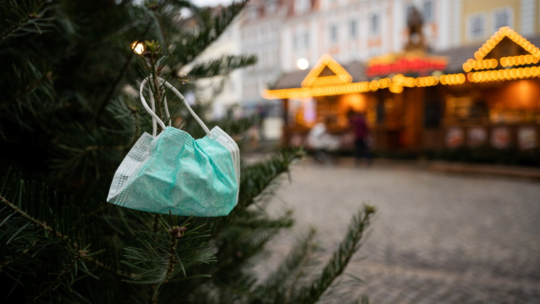 Ein Bild, das das ganze Dilemma dieser Zeit ausdrückt: Ein Mund-Nase-Schutz hängt an einem Weihnachtsbaum am Görlitzer Obermarkt.