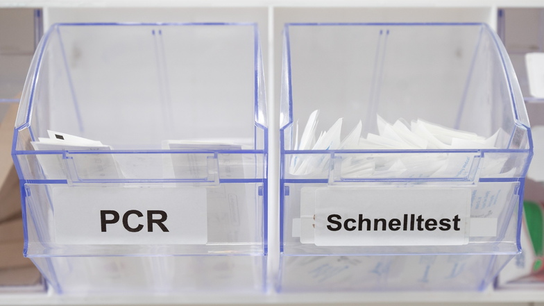Abstrichstäbchen für PCR-Tests (l) und Corona-Schnelltests liegen in einem Dresdner Testcenter