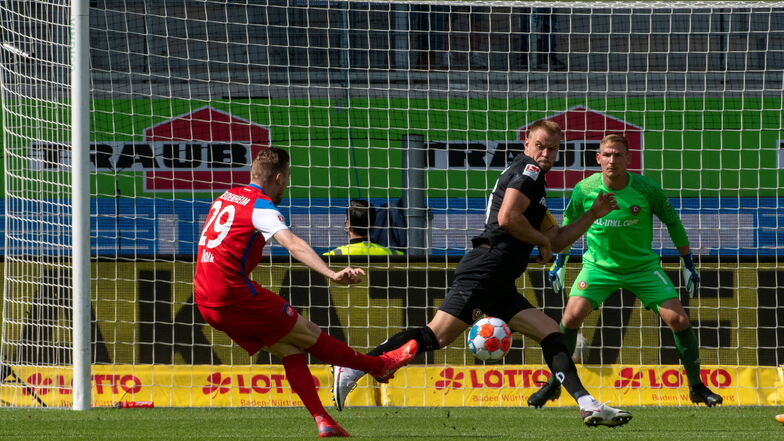 Dynamos Kapitän Sebastian Mai versucht, seinen Fehler auszubügeln, aber Tobias Mohr (l.) trifft den Ball perfekt und erzielt das 1:0 für Heidenheim.