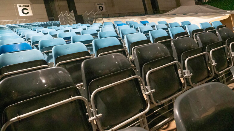Auf den Zuschauertribünen werden alte, blaue Sitze gegen neue, anthrazitfarbene getauscht.