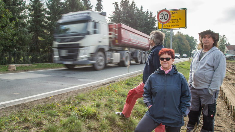 Wolfgang und Karin Bille stehen zusammen mit Nachbar Torsten Nitsche (rechts) am Ortseingang von Klitten. Die Geschwindigkeit ist auf 30 km/h reduziert, aber die wenigsten Kraftfahrer halten sich daran.