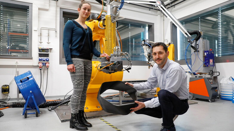 Dipl.-Ing. Michaela Stipkova und Dipl.-Ing. Jens Stein sind zwei der rund 30 Mitarbeiter des Fraunhofer Kunststoffzentrums Oberlausitz in Zittau. Hier sind sie an einem roboterbasierten 3-D-Drucker.
