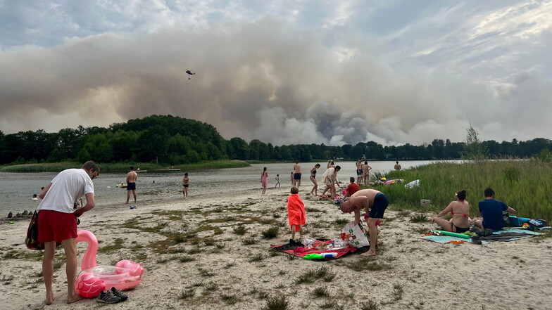 Ausflügler verbringen den heißen Tag am Seddiner See: Dort nahmen auch die Löschhubschrauber wegen des Waldbrandes bei Treuenbrietzen Wasser auf