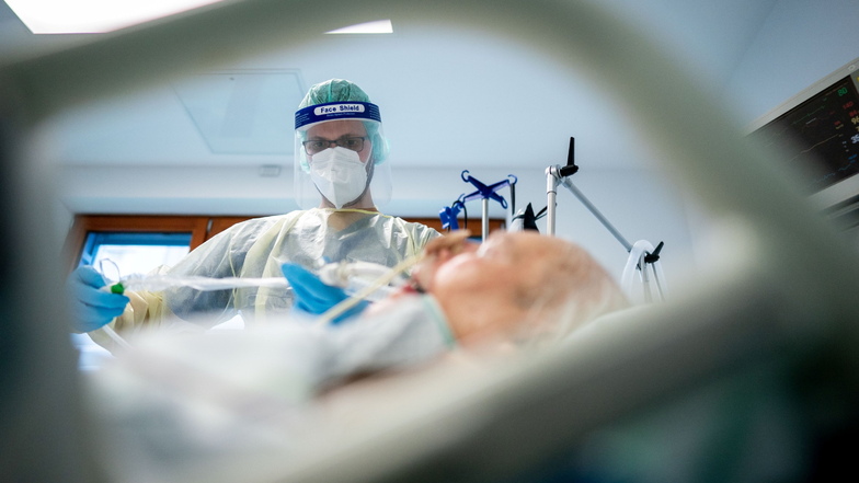 Ein Intensivpfleger kümmert sich auf einer Intensivstation um einem Corona-Patienten.
