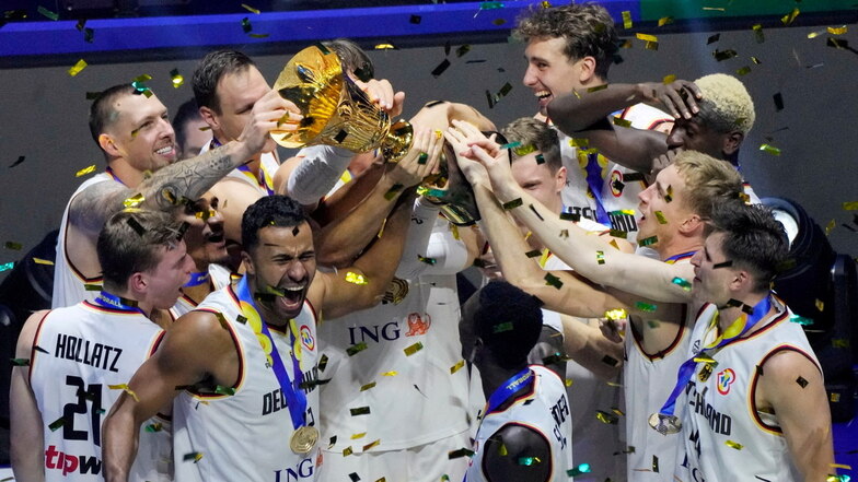 Das deutsche Basketball-Nationalteam jubelt mit der WM-Trophäe nach dem Finalsieg über Serbien.