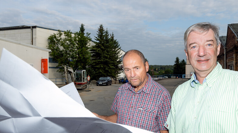 Geschäftsführer Ulf Mildner (rechts) und Bauleiter Andreas Förster haben die Baupläne parat. Ab Ende August wird die Zufahrt vom Drebnitzer Weg zum Gewerbepark der Firma Aicher saniert. Eine von mehreren Baustellen des Unternehmens 2019.