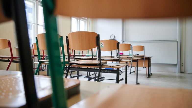 In einem Klassenzimmer stehen die Stühle auf den Tischen. Viele Schulen in Dresden bleiben derzeit wegen Coronafällen geschlossen.
