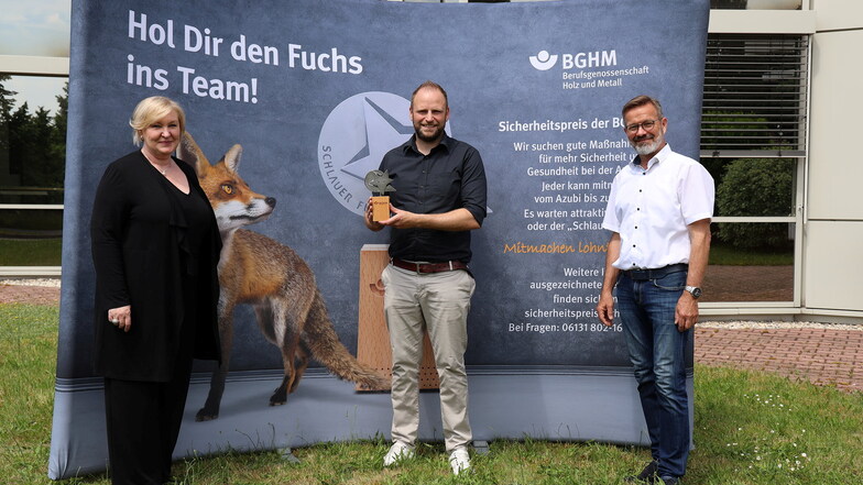 Ute Emsel und Andreas Brendel von der Berufsgenossenschaft haben Kay Maschke (Mitte) von OKA Büromöbel den "Schlauen Fuchs" überreicht.