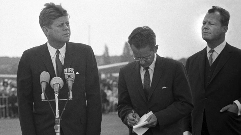 Zu Besuch in Berlin: US-Präsident John F. Kennedy (l) nach seiner Ankunft auf dem militärischen Teil des Flughafens Tegel in Berlin im Juli 1963 mit dem Regierenden Bürgermeister der geteilten Stadt Berlin, Willy Brandt (r).
