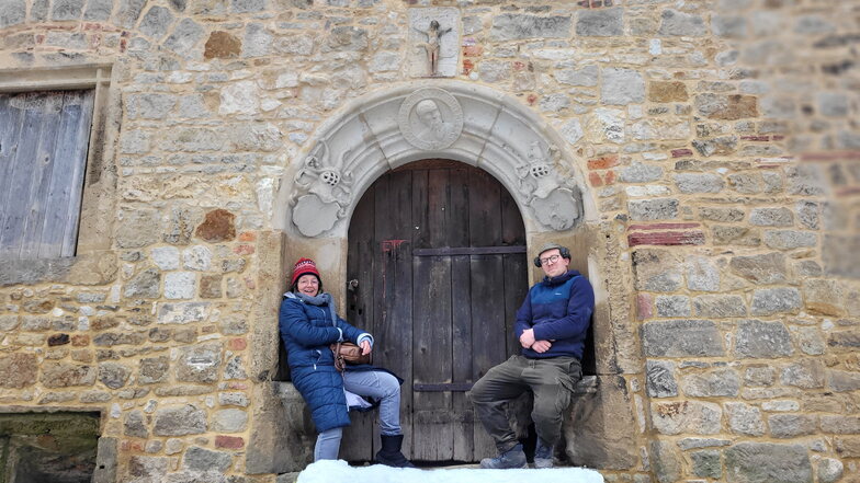 Katja Seifert und Paul Kuhne im Renaissanceportal des Schlosses, die Jesusfigur 
über ihnen, dem Paul Kuhne wieder Beine gemacht hat.