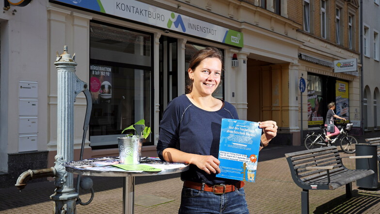 Anja Dietel zeigt vor ihrem Kontaktbüro die Flyer für die Aktion "Innenstadtdetektive".