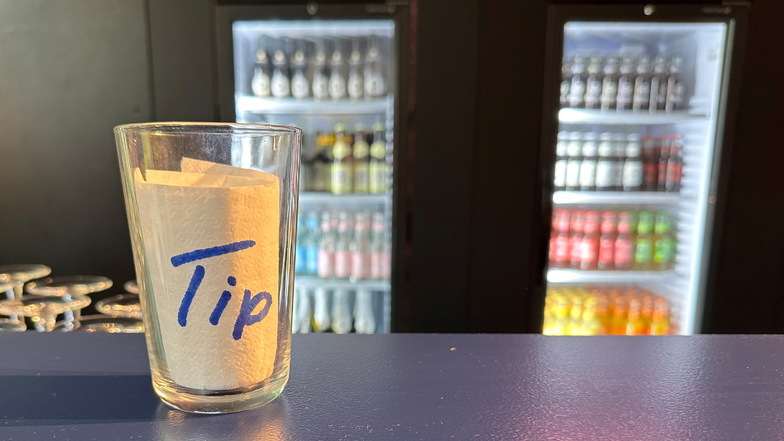 Ein Glas für Trinkgeld steht an einer Bar.
