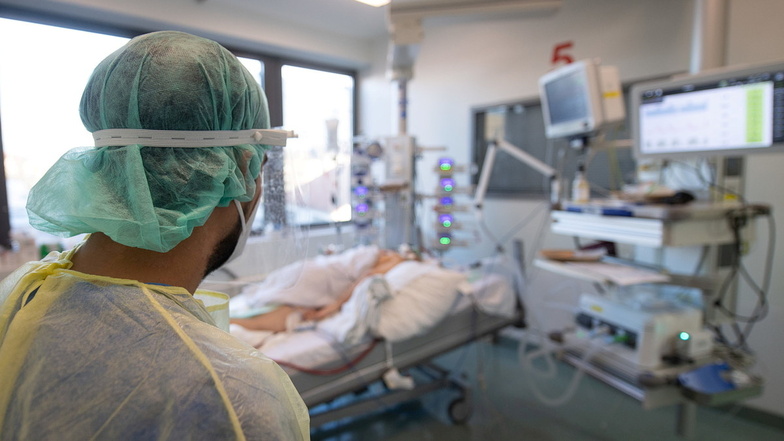 Ein Pfleger steht auf der Intensivstation für Corona-Patienten an einem Bett. In einigen Medien häufen sich Job-Anzeigen ungeimpfter Pfleger auffallend stark.