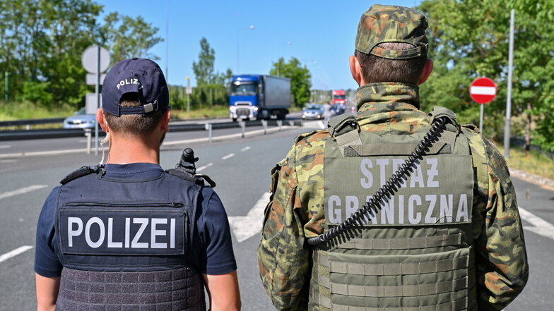 Ein deutscher Polizist und sein polnischer Kollegen stehen an einem Autobahngrenzübergang. Sachsen und Brandenburg drängen auf feste Grenzkontrollen nach Polen.