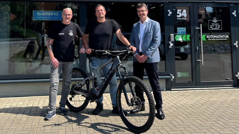 Bikepoint-Geschäftsführer Stefan Wiesner (v. l.) übergibt an Sten Frydrich vom Landratsamt Bautzen ein neues E-Bike, das dieser über das „Job-Rad“ finanziert. Der Erste Beigeordnete Jörg Szewczyk gratuliert zum neuen Rad.