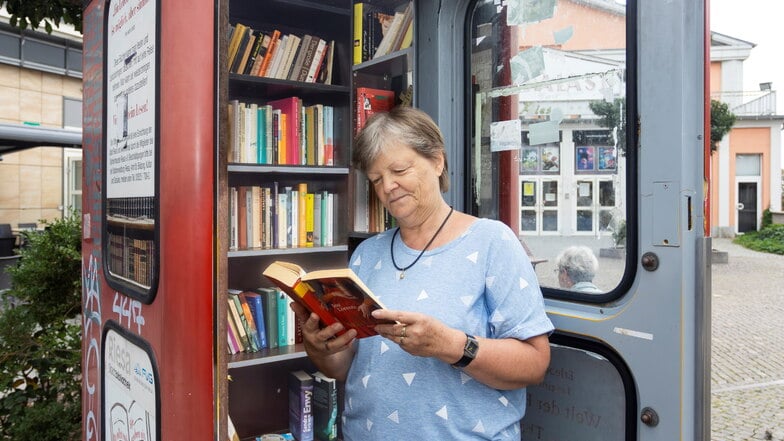 Heike Berthold vor der Büchertelefonzelle am Mannheimer Platz in Riesa. Der Schrank, der hier seit 2009 steht, werde immer noch gut genutzt - aber der Vandalismus macht Probleme.