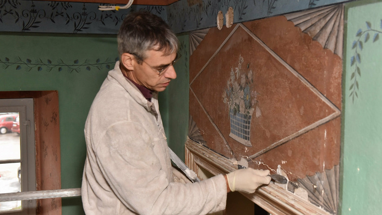 Kirchenmaler Lutz Senninger bereitet im Haupthaus den Untergrund vor, um die historischen Wandmalereien zu restaurieren.