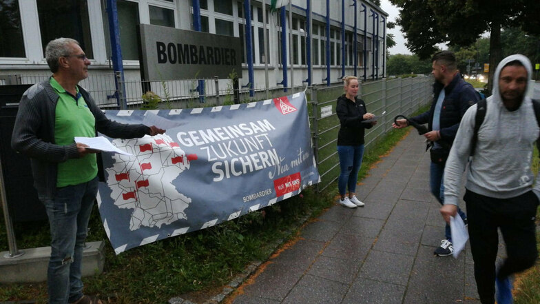 Vertreter der IG Metall verteilen am Donnerstag Flugblätter an die Beschäftigten. Darauf zu lesen: die Forderungen der Gewerkschaft zur Übernahme von Bombardier durch den französischen Alstom-Konzern.
