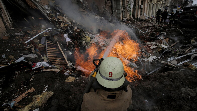 Ein Feuerwehrmann löscht in Charkiw ein Wohnhaus nach einem russischen Raketenangriff.