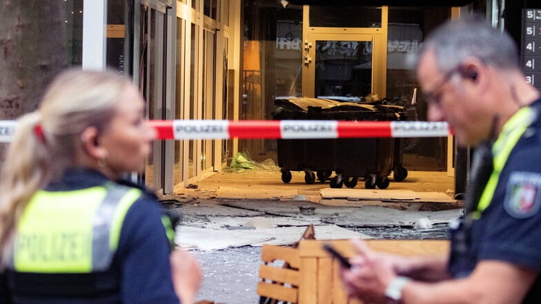 Polizeibeamte stehen nach einer Explosion vor einem beschädigten   Gebäude in der Kölner Innenstadt.