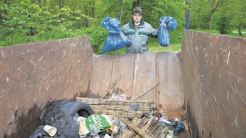 Revierförster Michael Blaß wirft den gesammelten Müll in einen Container.
