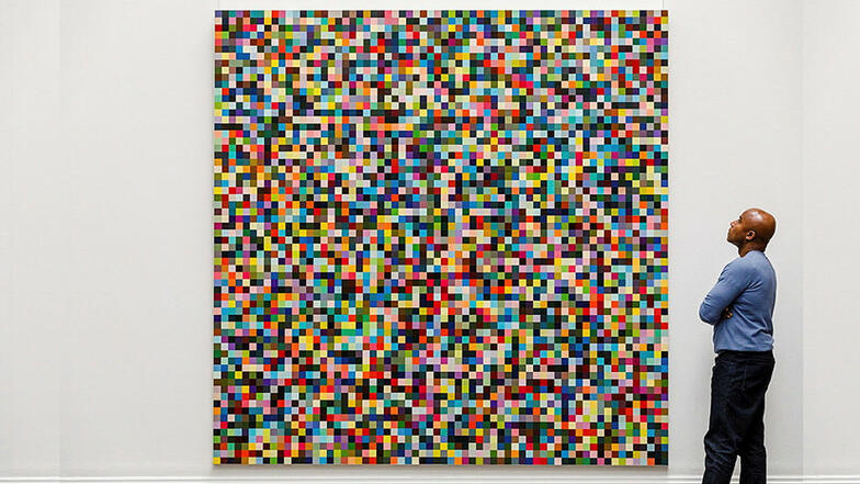 Ein Angestellter des Auktionshaus Sotheby's betrachtet das Gemälde "4096 Farben" des deutschen Künstlers Gerhard Richter.