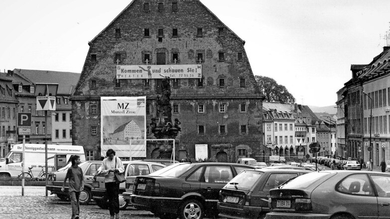 Das Salzhaus vor der Sanierung in den 1990er Jahren. Auf dem Banner links wurde damals für den „Marstall Zittau“ geworben. Als Blickfang fällt je ein Sims als Traufkante an den Giebelseiten auf.