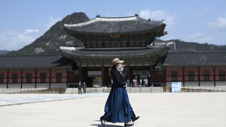 Frauen mit Mundschutz gehen am Gyeongbokgung Palast in Seoul vorbei. In Südkorea ist ein Ende der Corona-Pandemie absehbar.