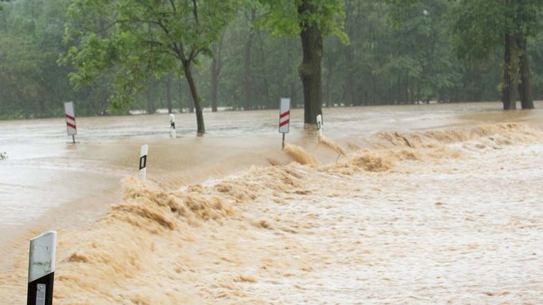 Wassermassen überfluten nach starken Regenfällen Straßen im Vogtland wie hier in der Nähe von Adorf.