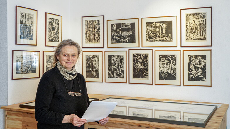Die Vorsitzende des Ernst-Rietschel-Kulturrings, Sabine Schubert, zeigt in Rietschels Geburtshaus in Pulsnitz Holzschnitte und Zeichnungen von Kurt Grässel.