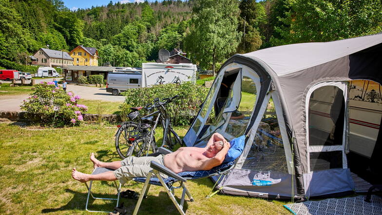 Ein Urlauber sonnt sich auf dem Campingplatz Ostrauer Mühle in Bad Schandau. Noch haben die Plätze freie Kapazitäten.