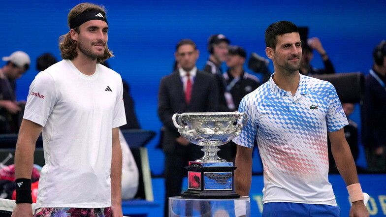 Stefanos Tsitsipas (l) steht für ein Foto mit Novak Djokovic vor dem Finale des Herreneinzels neben dem Pokal.