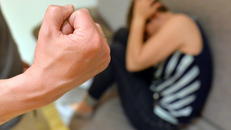 Eine Frau versucht, sich vor der Gewalt eines Mannes zu schützen (gestellte Szene). Die häusliche Gewalt ging in Sachsen und bundesweit leicht zurück.