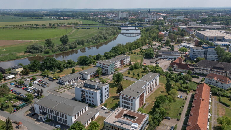 Das Gelände der Riesaer BA (im Vordergrund) in einer Luftaufnahme. Der Campus liegt im Stadtteil Gröba zwischen Elbe und Bundesstraße 182.