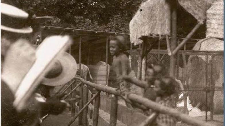 Zoobesucher mustern 1906 die Bewohner eines "Afrikanischen Dorfes" - und diese mustern zurück.