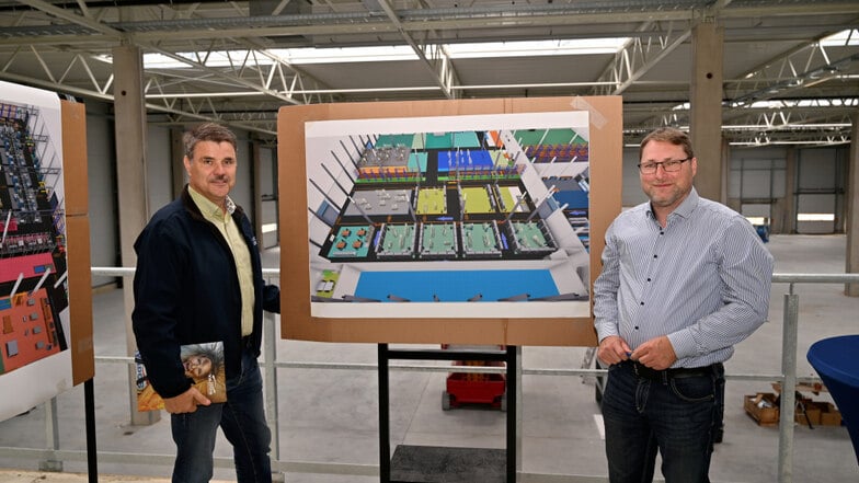 Blick in die kleinere der neuen Hallen, die Yados bauen lässt. Prokurist Olaf Besser und Geschäftsführer Frank Stiehler stehen hier vor dem Plan, der die künftige Nutzung zeigt.