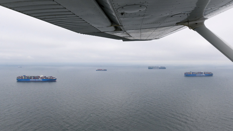 Das Containerschiff Ever Grade von der Reederei Evergreen (hr) liegt vor Anker in der Nordsee neben weiteren Containerschiffen, die weder ent- noch beladen werden können.