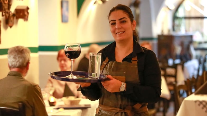 Mariam Sdouga serviert den ersten Gästen des Restaurants, das sie mit ihrem Mann betreibt, die Getränke.
