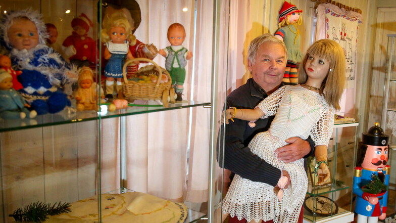 Der Chef des Heimatmuseums in Großröhrsdorf, Matthias Hennig, hält eine große Puppe aus der Sammlung von Gudrun Schöne im Arm. Im Museum werden ab Sonnabend Puppen und Handarbeiten der Lichtenbergerin gezeigt.