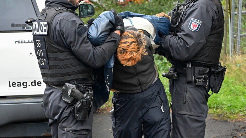 Einer der Jänschwalde-Blockierer wird von der Polizei abgeführt.