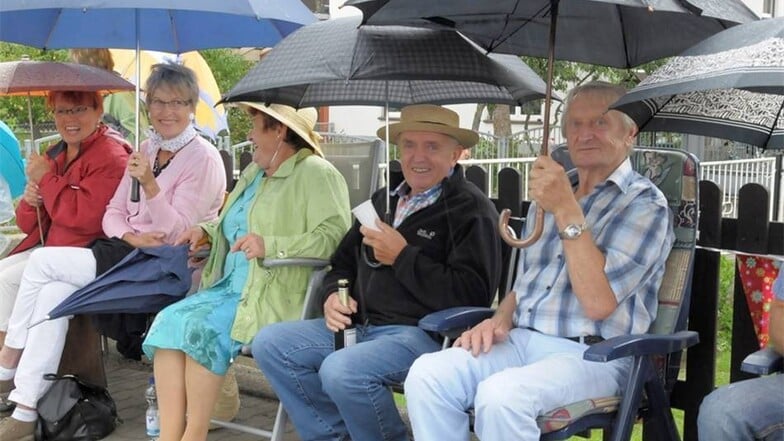 Zuschauer unterm Regenschirm