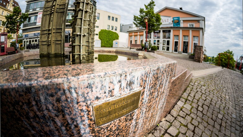 Der vom Künstler Benno Werth vor 30 Jahren geschaffene Brunnen vorm Riesaer Kino. Ein Schild weist darauf hin, dass das kühle Nass im Brunnen kein Trinkwasser ist. Bald soll es aber auch einen Trinkwasserbrunnen am Platz geben.