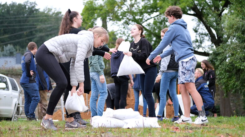 Übung für den Ernstfall. Neuntklässler des Gymnasiums in Nossen lernen, wie bei Hochwasser Sandsäcke richtig gestapelt werden.