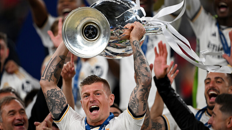 Madrids Toni Kroos jubelt mit dem Champions-League-Pokal. Es ist der 34. Titel des Deutschen. Toni Kroos ist damit der erfolgreichste deutsche Spieler der Geschichte.
